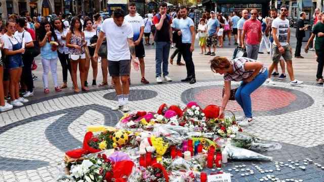 Flores depositadas por ciudadanos anónimos en el mosaico de Miró en la Rambla / EFE