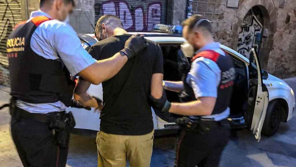 Un presunto ladrón es conducido hasta un coche policial por dos mossos / MOSSOS D'ESQUADRA