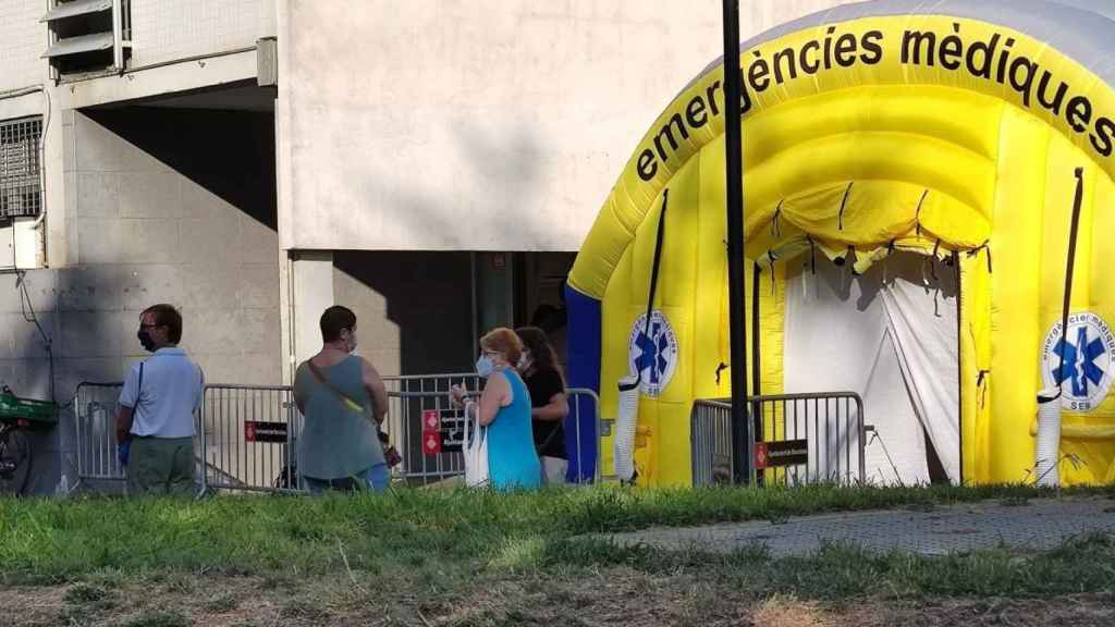 Un grupo de vecinos esperan delante de la carpa instalada en el Besòs i Maresme / TWITTER