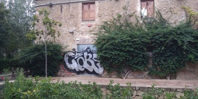 La parte delantera de Can Miralletes, tapiada y con un gran grafiti / JORDI SUBIRANA