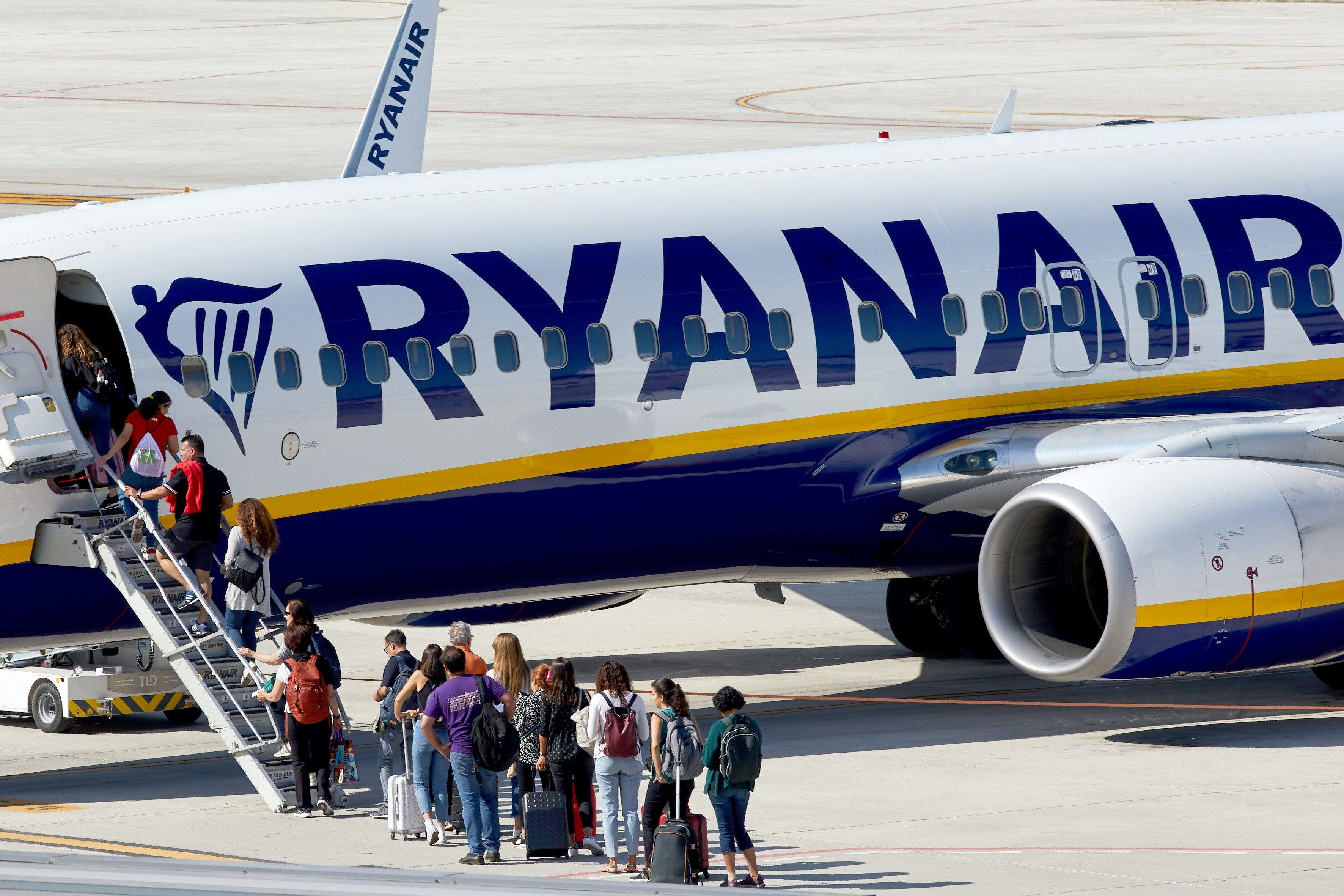 Dos decenas de pasajeros esperando para subir al vuelo de un avión de Ryanair / EFE