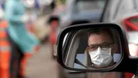 Un hombre con una mascarilla en el interior de un turismo / EFE