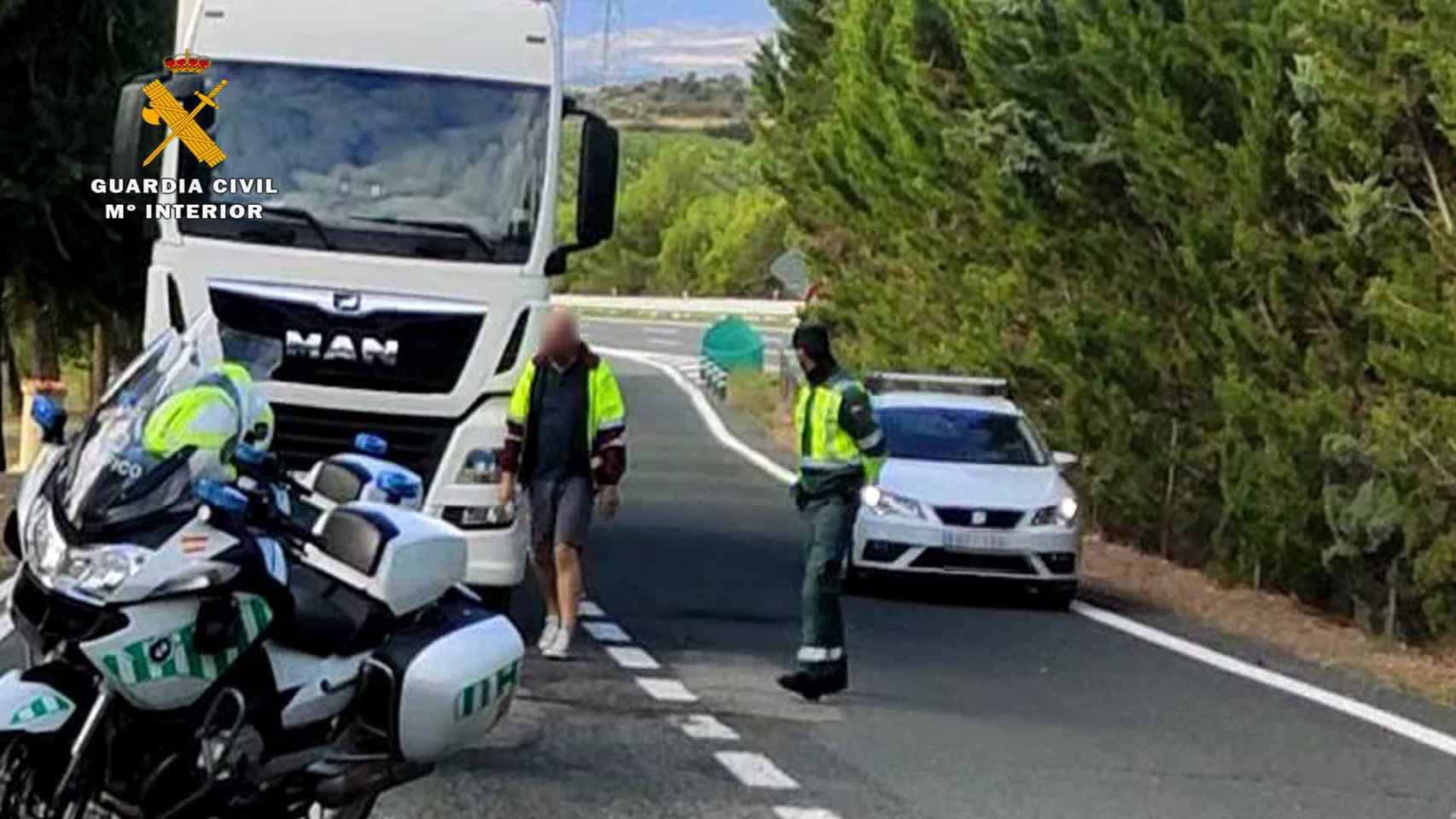 Un camión estacionado en la carretera junto a dos policías / GUARDIA CIVIL