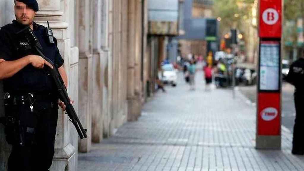 Imagen de un agente de los Mossos d'Esquadra con una arma larga vigilando Las Ramblas de Barcelona / EFE