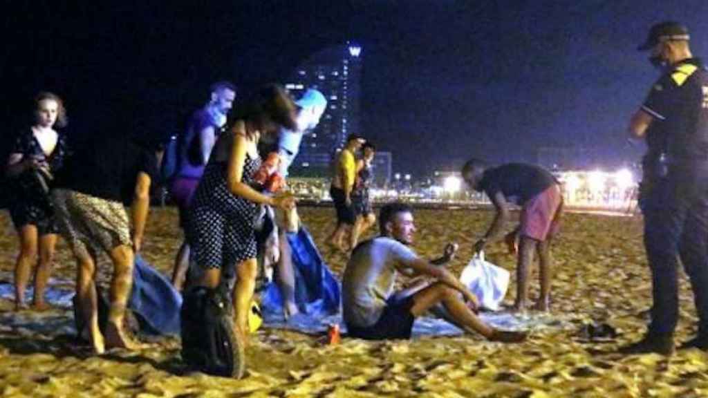 Jóvenes en un botellón, junto a la Guardia Urbana, en una playa de Barcelona / EUROPA PRESS