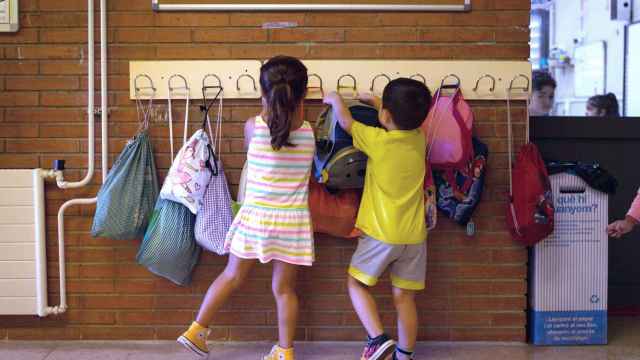 Dos niños dejan sus pertenencias en los colgadores en un colegio público / EFE