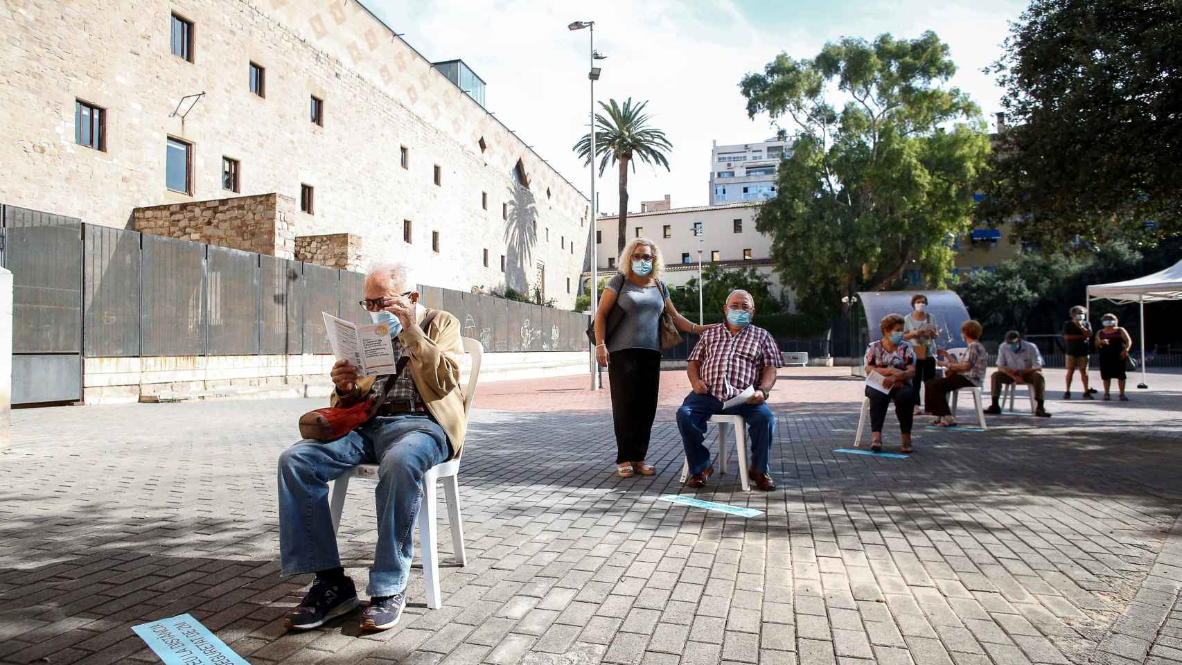 Varias personas esperan para hacerse una prueba PCR en el Raval recientemente / EFE