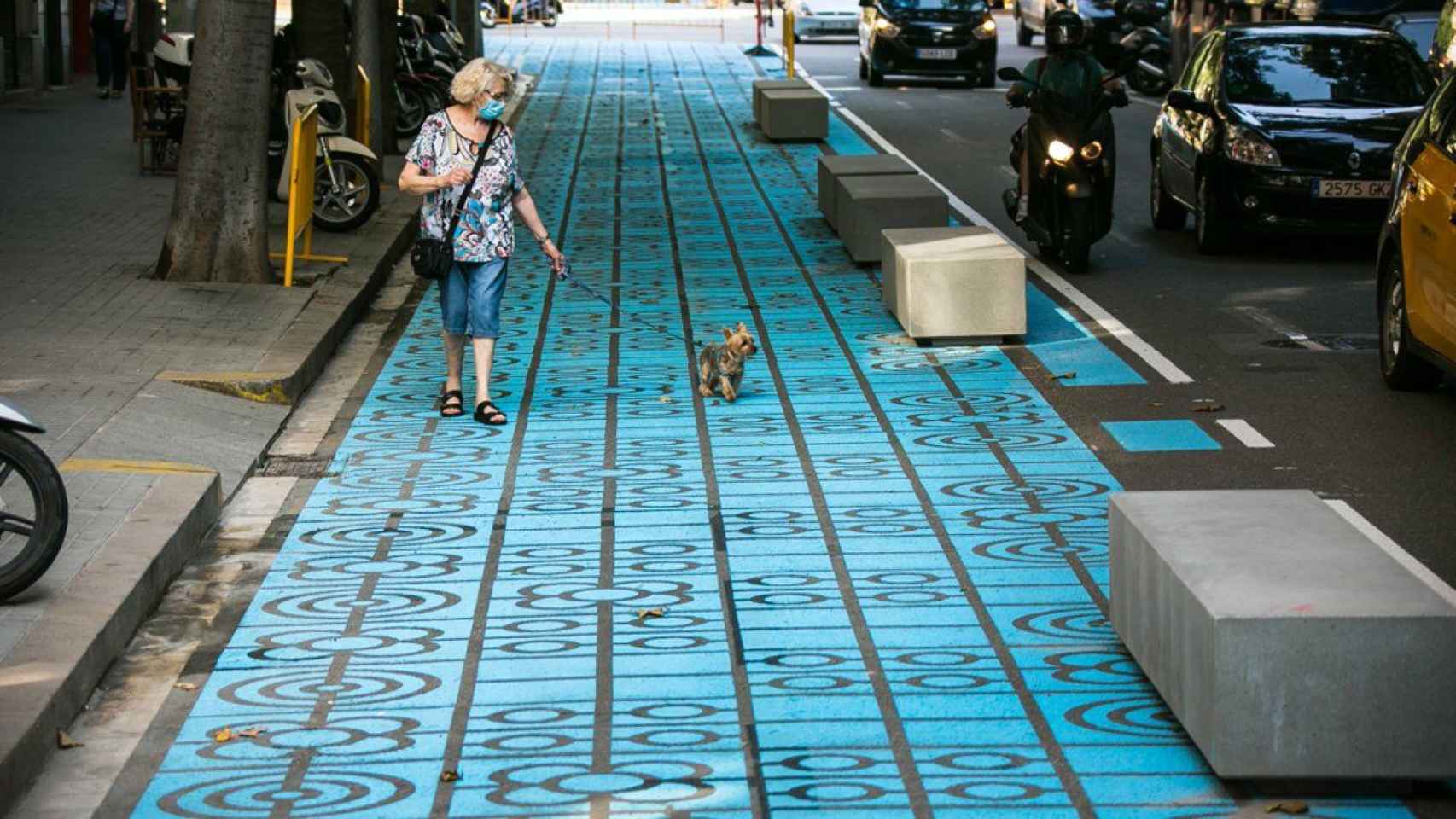 Bancos de hormigón y baldosas pintadas de azul en una calle de Barcelona