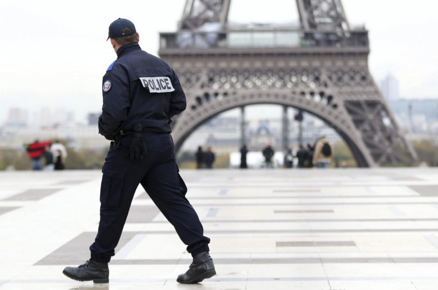 Un gendarme delante de la Torre Eiffel de París