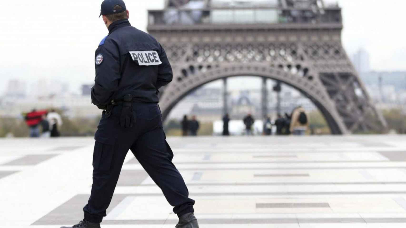 Un gendarmería delante de la Torre Eiffel de París