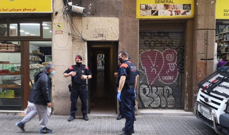 Varios agentes de la policía en la entrada de una vivienda del Raval / G.A.