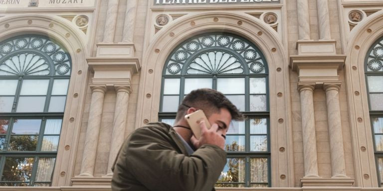 Un hombre habla por el móvil a su paso por delante del Liceu / PABLO MIRANZO