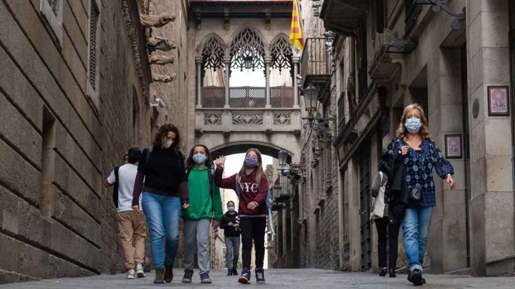 Personas caminan debajo del puente de estilo gótico del Carrer del Bisbe / PABLO MIRANZO