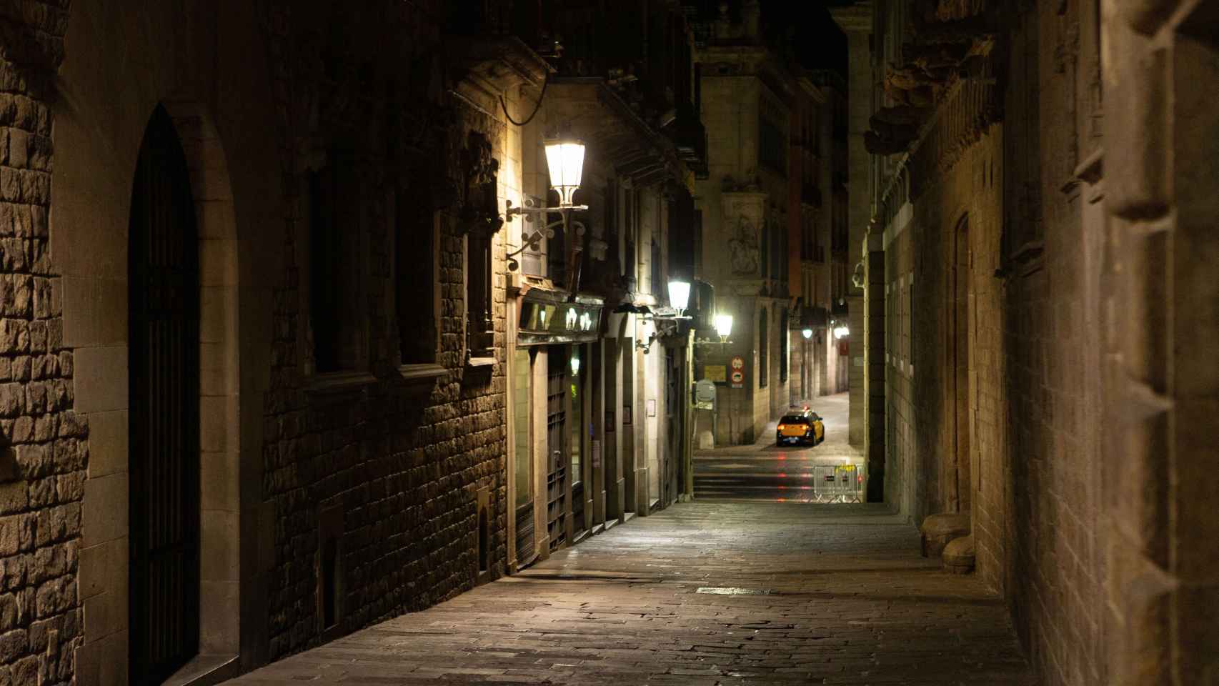 Aspecto de la calle del Bisbe situada en el casco antiguo de Barcelona, durante el segundo día de la aplicación del toque de queda/ EFE - Enric Fontcuberta