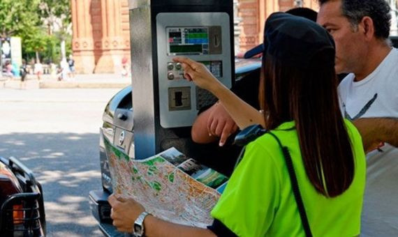 Una agente del área verde de Barcelona, ayudando a un conductor / CG