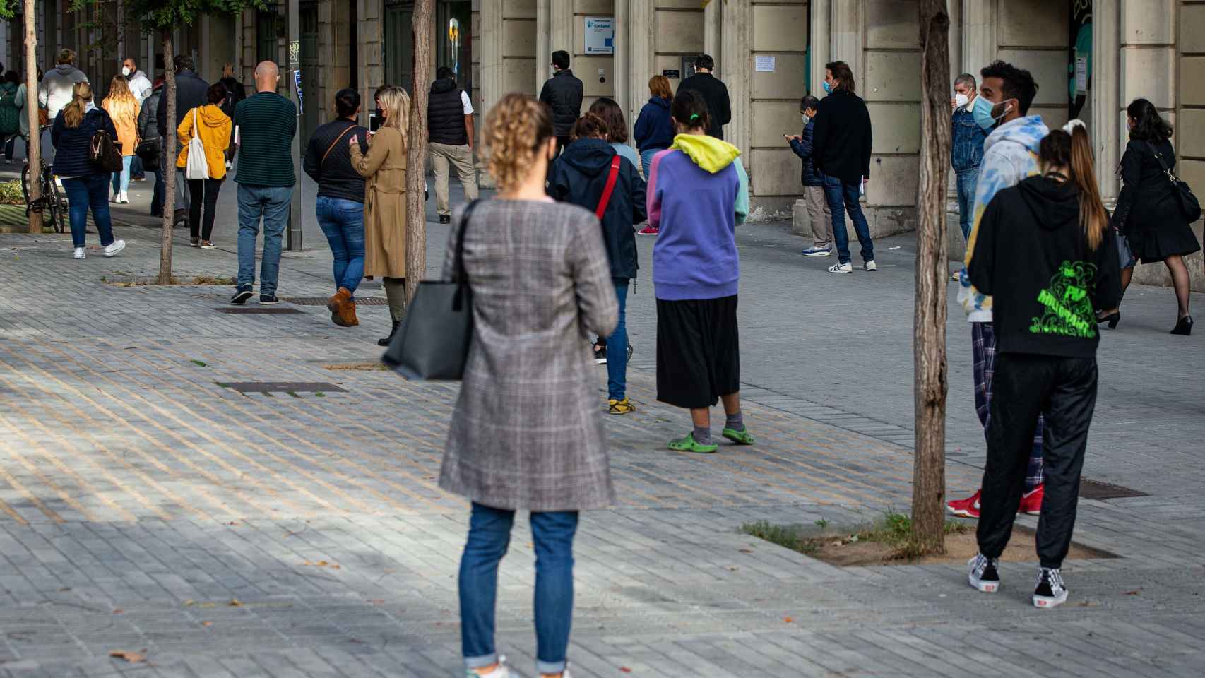 Numerosas personas hacen cola para acceder a la carpa montada para la realización de pruebas PCR frente al CAP del Passeig Sant Joan de Barcelona este miércoles / EFE- ENRIC