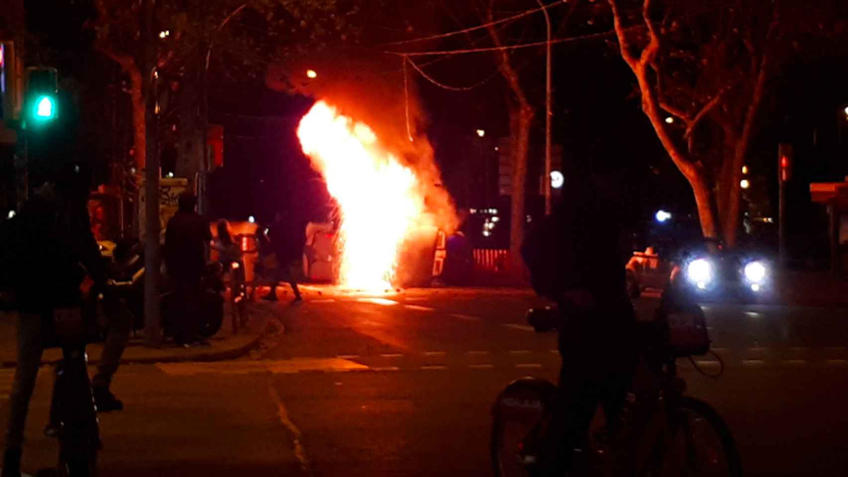 Contenedores en llamas en la plaza Urquinaona de Barcelona, alcanzando las luces de Navidad