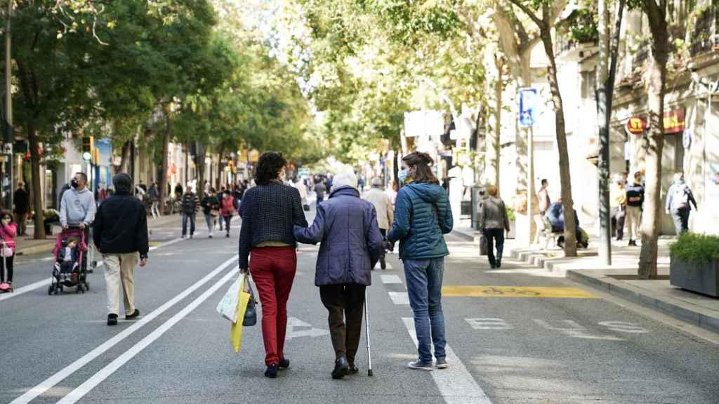 Tres mujeres pasean por la calle de Sants durante una jornada de ‘Obrim Carrers’