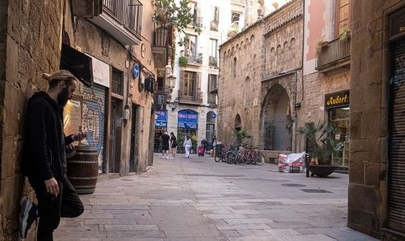 Un hombre usando su movil en la placeta d'En Marcus / PABLO MIRANZO