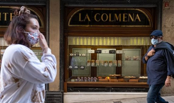 Gente camina delante del escaparate de la pastelería Colmena en la Plaça de l´Àngel  / PABLO MIRANZO