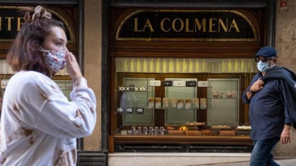 Gente camina delante del escaparate de la pastelería La Colmena de Barcelona