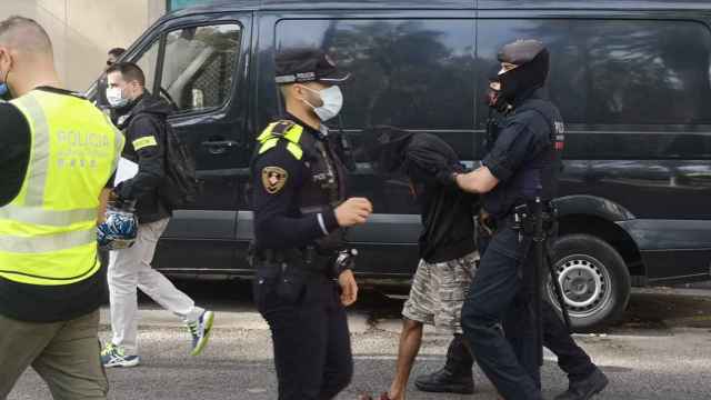 Los Mossos se llevan a un detenido en El Raval durante la operación 'Coliseo' / G.A