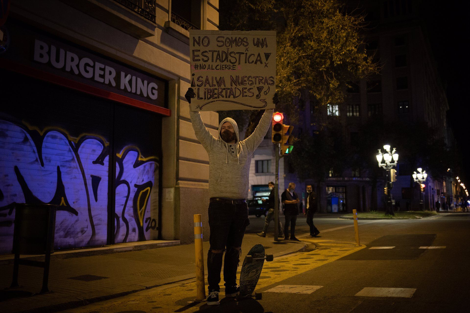 Una persona participa en una concentración de trabajadores del sector hostelero y el ocio nocturno en la plaza Urquinaona / EUROPA PRESS - David Zorrakino