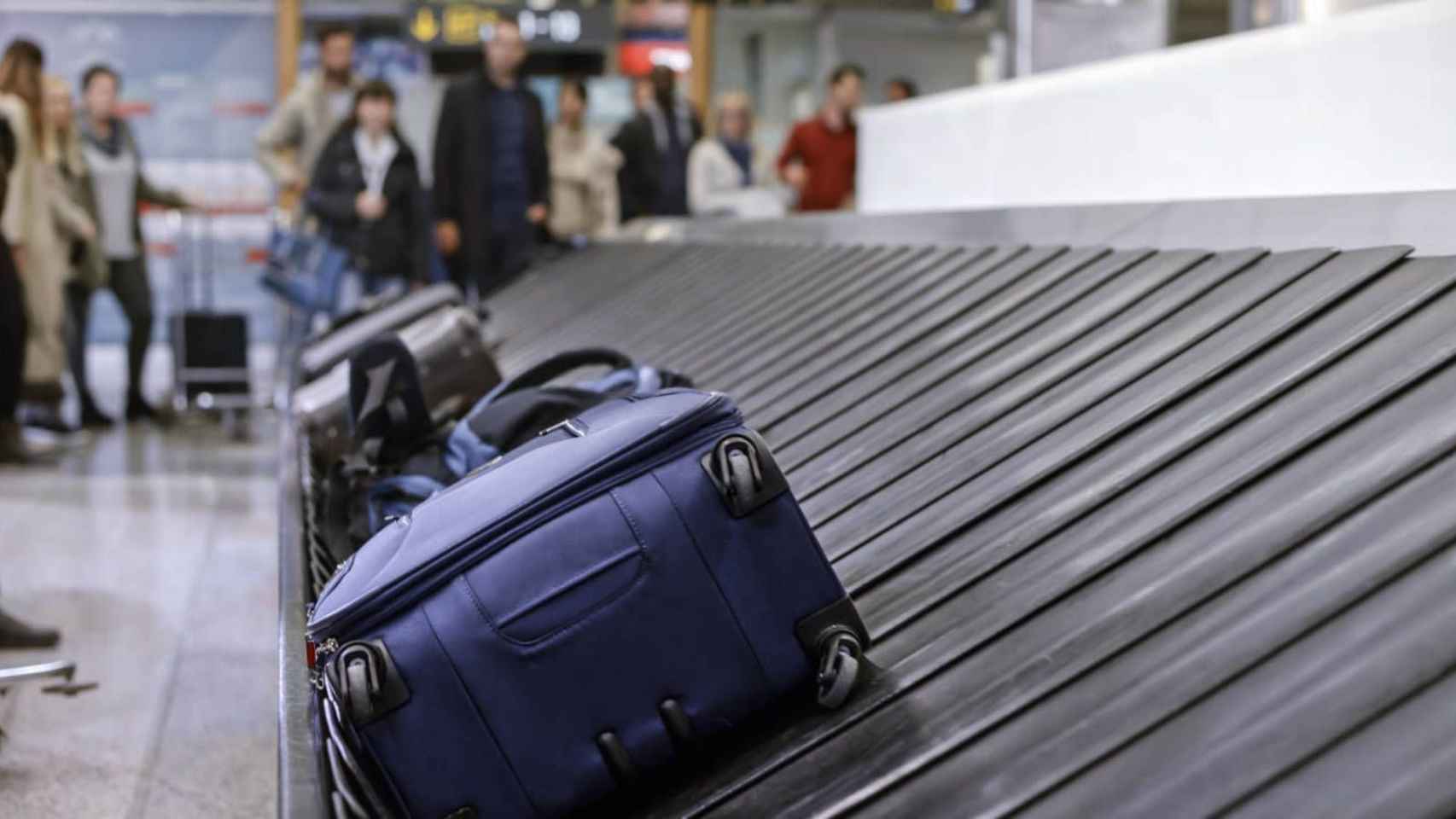Varias maletas en una cinta de aeropuerto