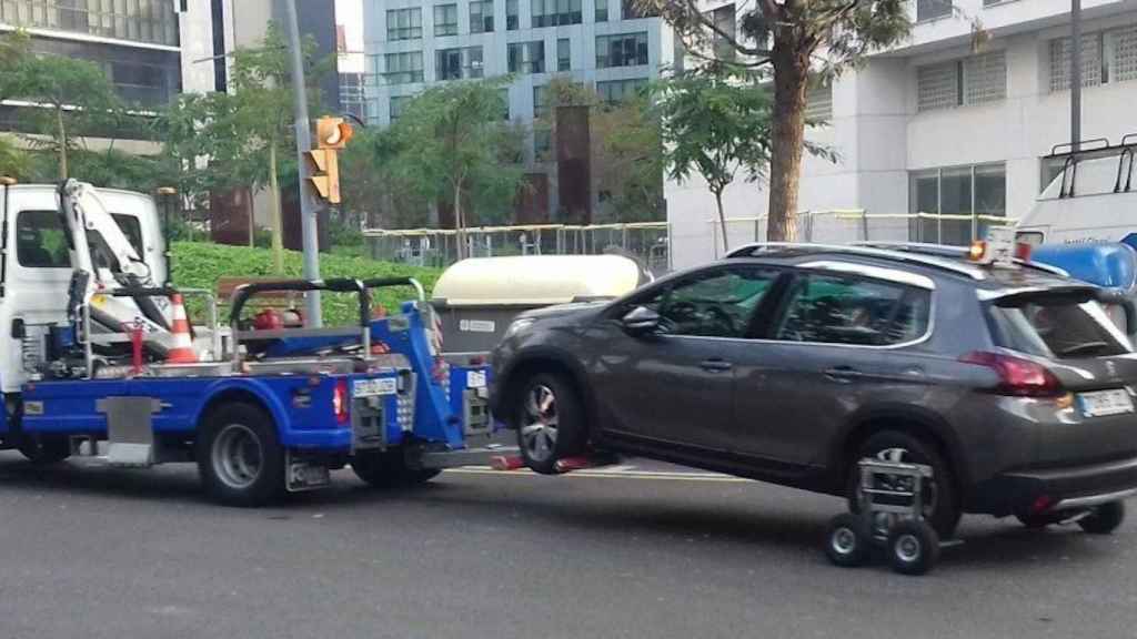 Una grúa se lleva un coche al depósito / JORDI SUBIRANA