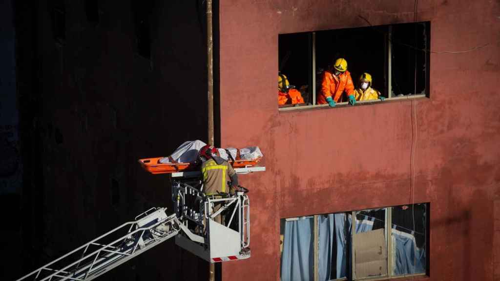 Los Bomberos de la Generalitat han retirado del interior de la nave dos de los tres cuerpos sin vida de las víctimas del incendio de Badalona (Barcelona)/ DAVID ZORRAKINO -