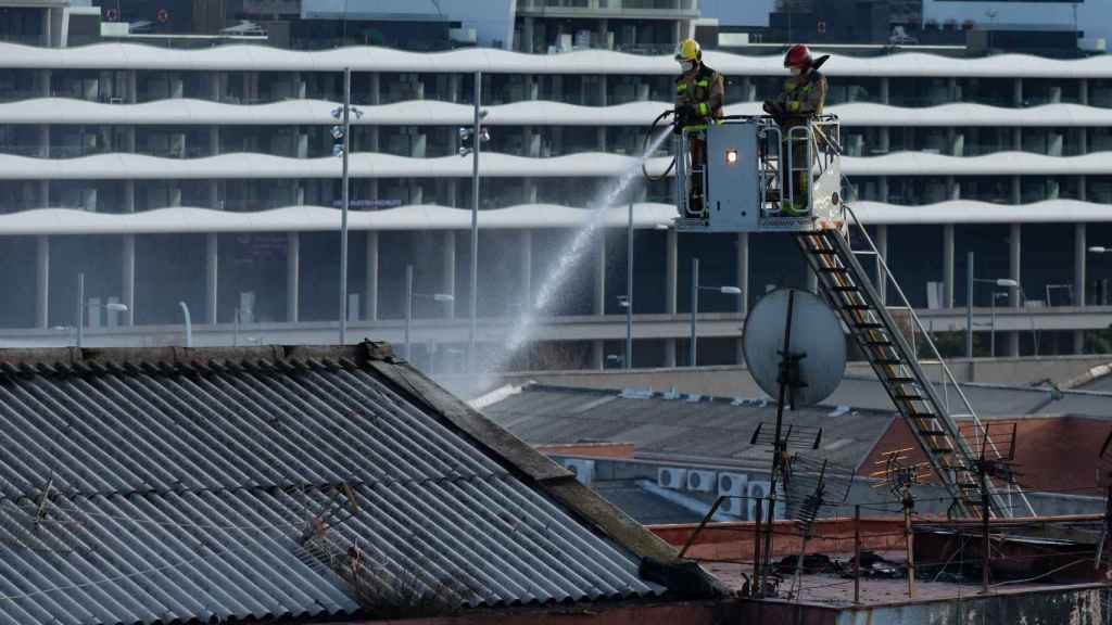 Bomberos realizan su trabajo para intentar acabar de sofocar el incendio, ya controlado / EFE - ENRIC FONTCUBERTA