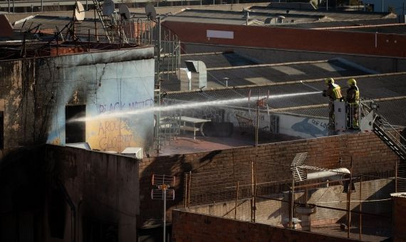 Bomberos apagan el fuego en la nave okupada / EFE 