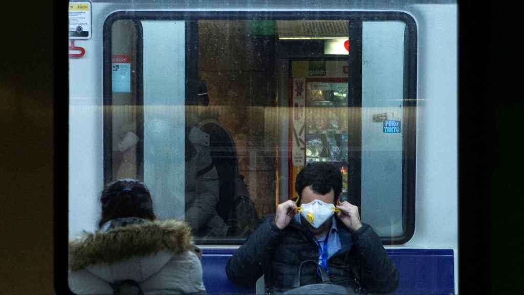 Un usuario del metro de Barcelona se coloca la mascarilla / EFE