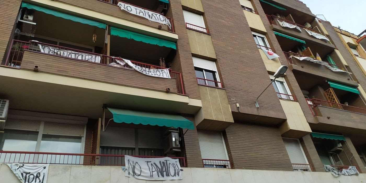 Edificios de la calle Puiggarí llenos de pancartas contra el tanatorio, que se situaría a solo unos metros de las viviendas/ ELISABET GONZALEZ