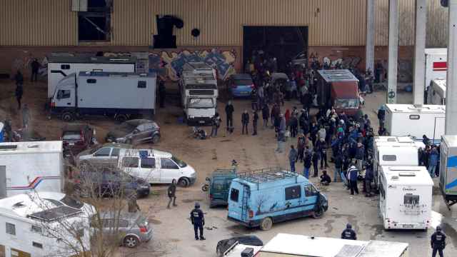 Decenas de asistentes a la 'rave' rodeados por agentes de Mossos esta tarde / EFE