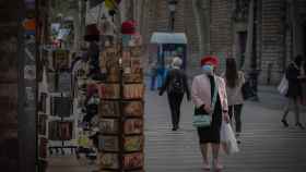 Una mujer frente a una tienda de artículos turísticos en Barcelona / EUROPA PRESS - David Zorrakino