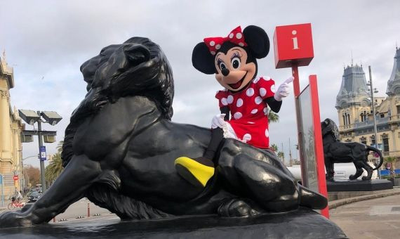 Jesús Fernández disfrazado de Minnie Mouse subido en uno de los leones del monumento de Colón / CEDIDA