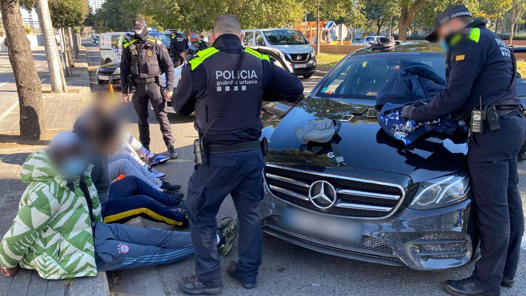 Los cuatro detenidos por la Urbana, en el suelo, junto al vehículo / TWITTER GUARDIA URBANA