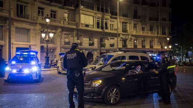 Unos agentes de la Urbana explicando qué se puede hacer y qué no este fin de semana en Barcelona a un conductor / EFE