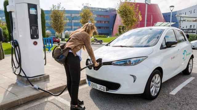 Una mujer cara su coche eléctrico en Barcelona