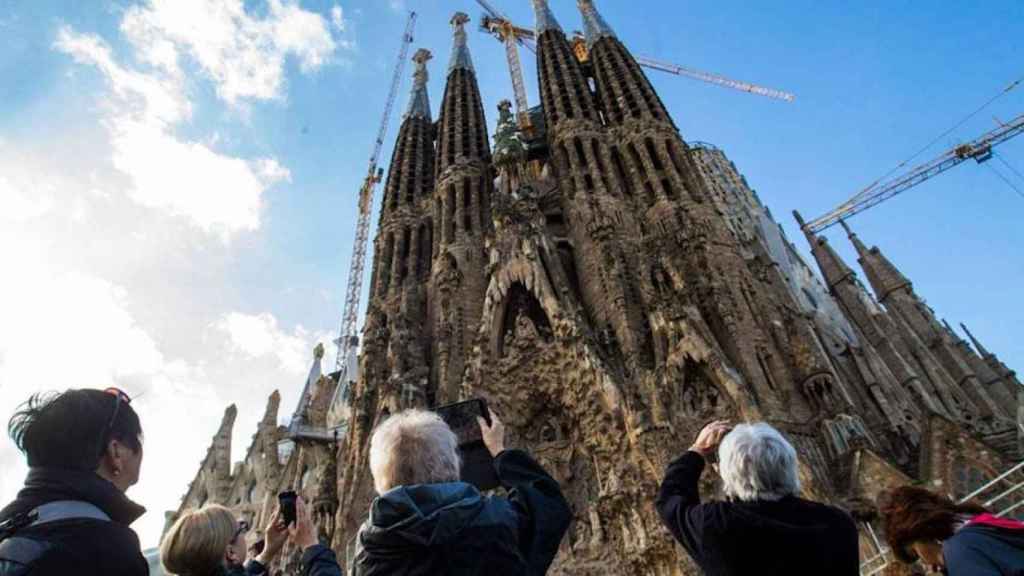 Turistas fotografían la Sagrada Família de Barcelona, uno de los monumentos religiosos de la ciudad