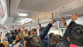 Un tren de la R1 de Rodalies a la altura de Badalona abarrotado este mediodía / METRÓPOLI ABIERTA