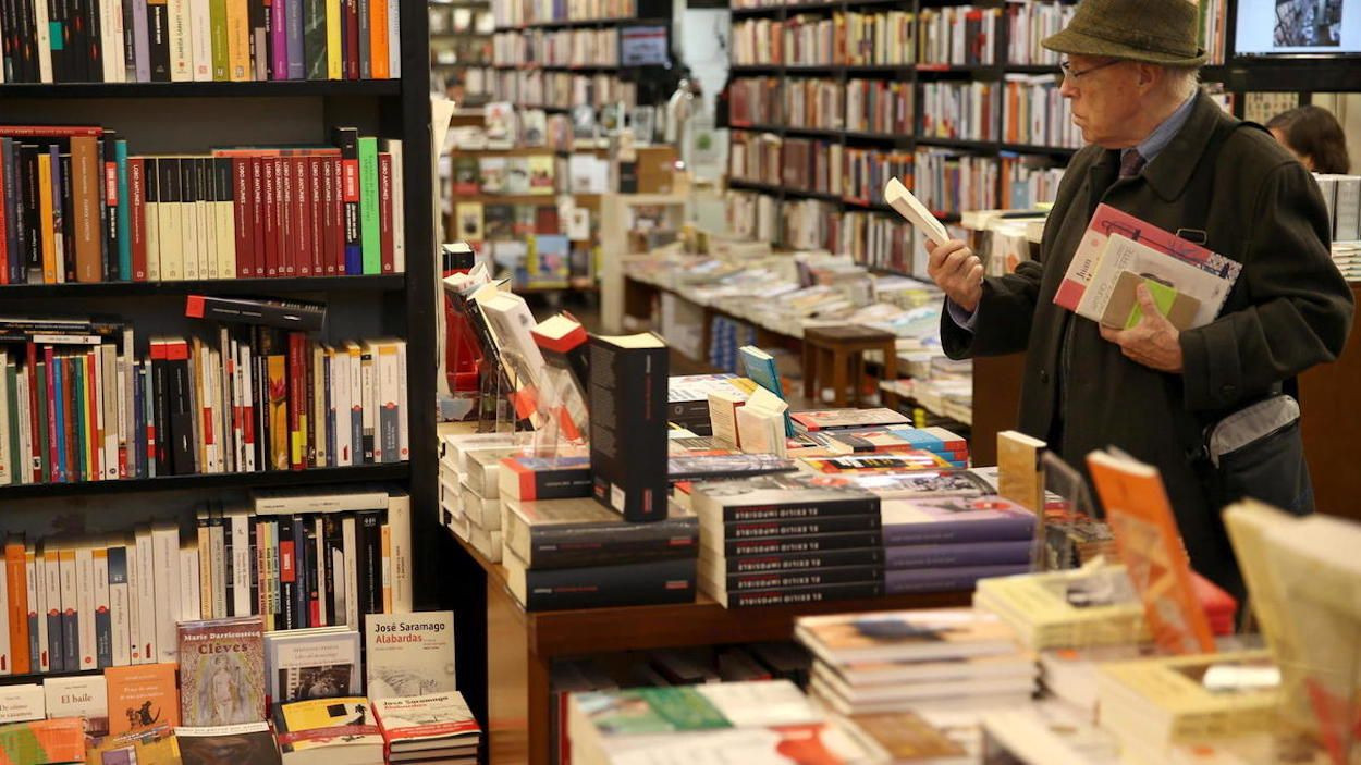 Una hombre hojea unos libros en la librería la Central de Barcelona / EFE