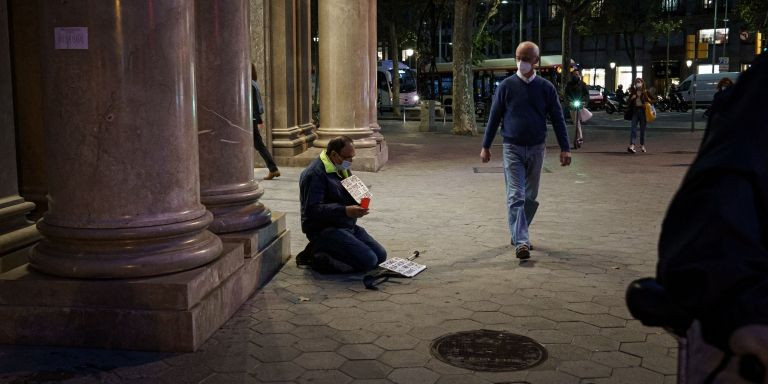 Un mendigo, cabizbajo, en la Gran Via de Barcelona / PABLO MIRANZO