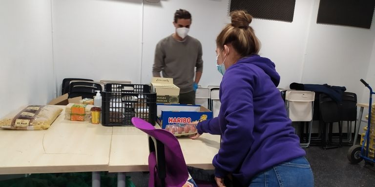 Un voluntario entregando la comida a la joven hondureña de 19 años que acude a la entidad / ELISABET GONZALEZ