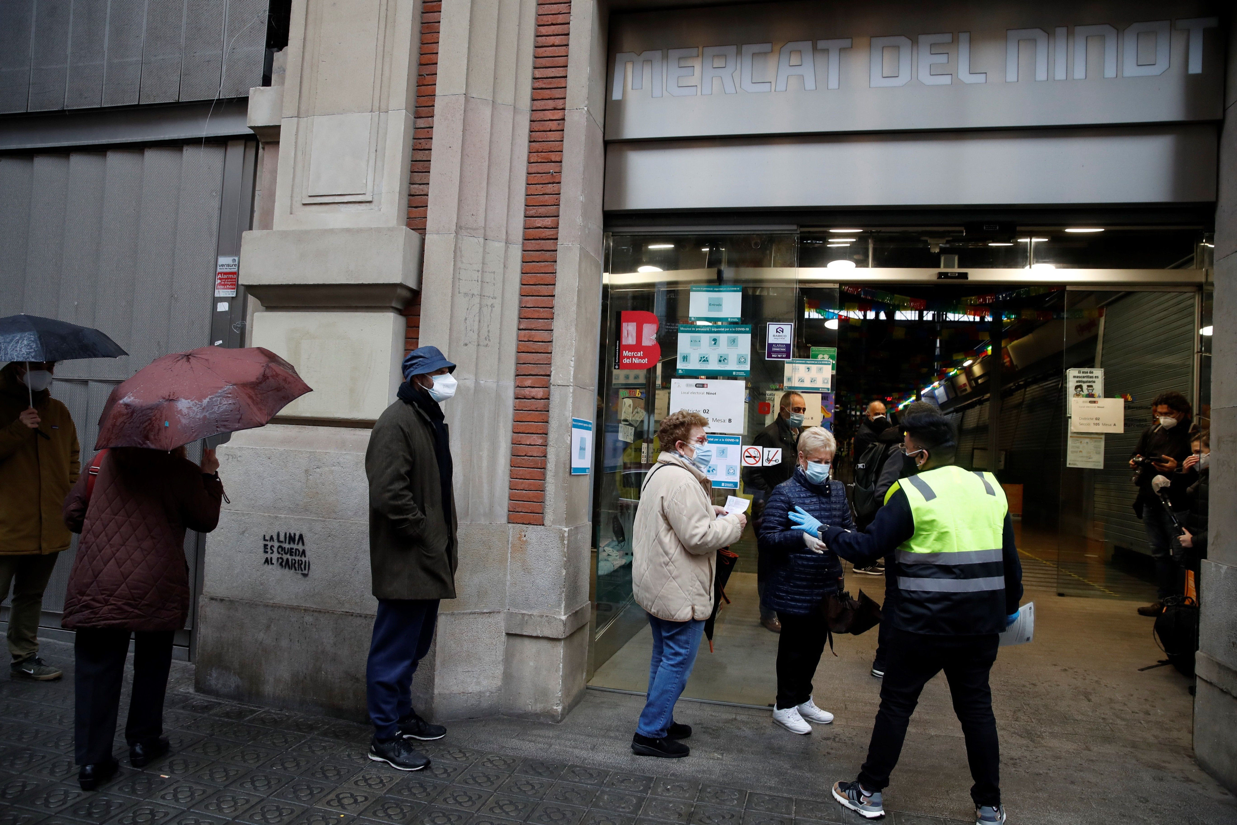 Varias personas hacen cola para votar en el colegio electoral situado en el Mercat del Ninot en Barcelona este domingo cuando se celebran las elecciones regionales / EFE - Toni Albir