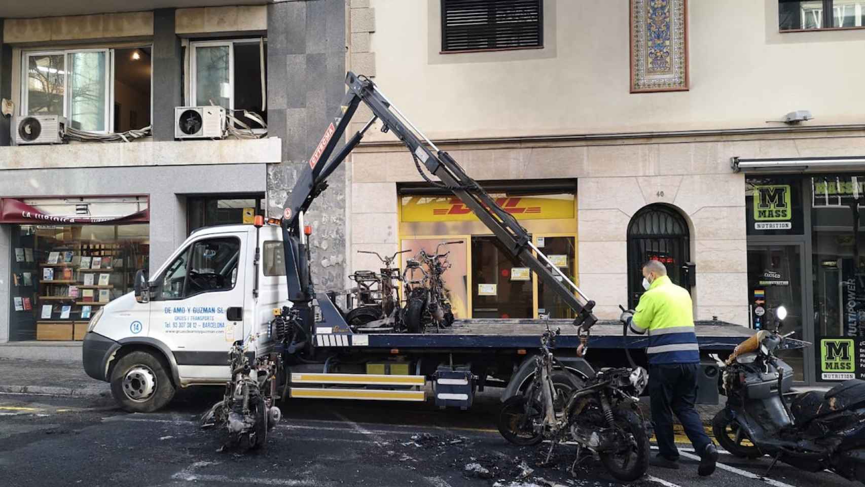 Una grúa retira motos quemadas por los destrozos de la protesta a favor de Hasél y criticados por Valls / METRÓPOLI ABIERTA - GUILLEM ANDRÉS