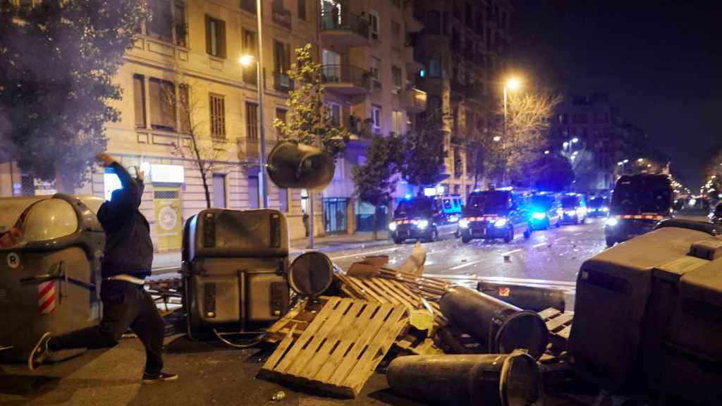 Un radical lanzando mobiliario urbano ayer jueves en Barcelona / EFE - ALEJANDRO GARCÍA