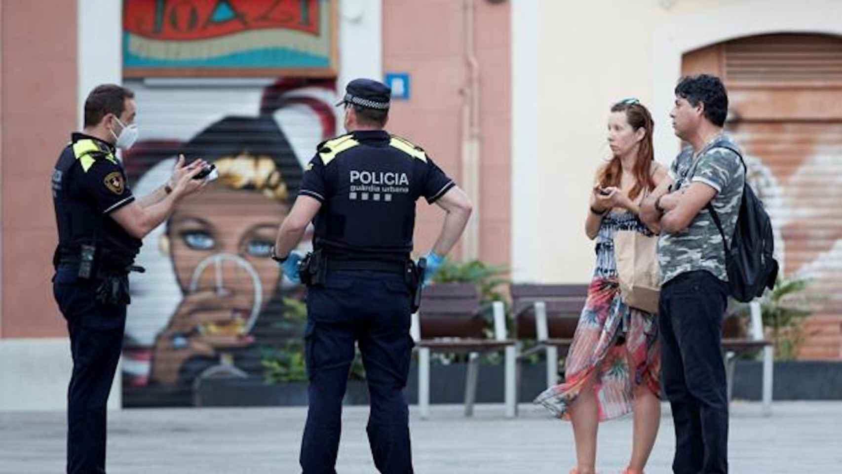 Agentes de la Guardia Urbana dan el alto a dos peatones sin mascarilla / EFE