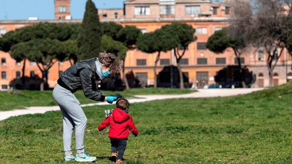 Una mujer pasea junto a un niño pequeño / EFE